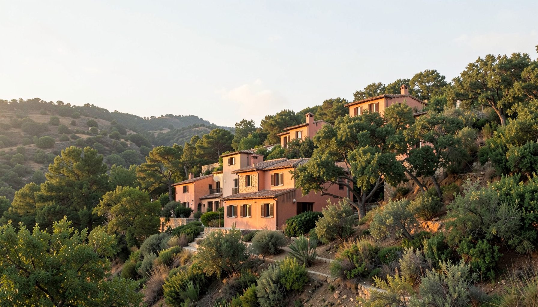 A serene hillside retreat with terracotta buildings nestled among green trees under a soft afternoon sky, warm earthy tones and gentle shadows